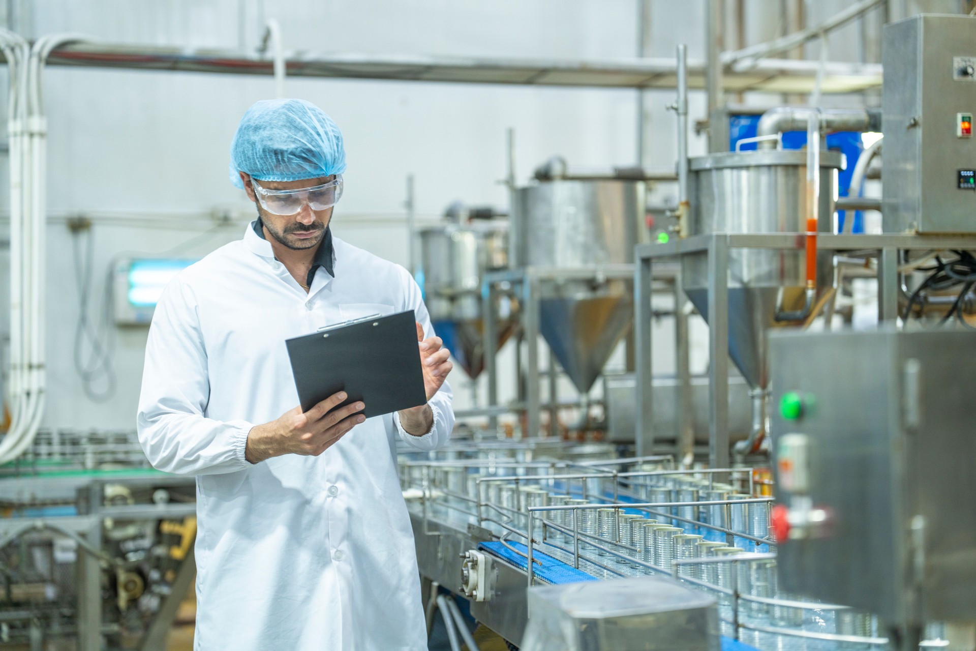 Factory technician in a clean uniform conducting a detailed inspection of a product, showcasing quality assurance, attention to detail, and adherence to safety and manufacturing standards.